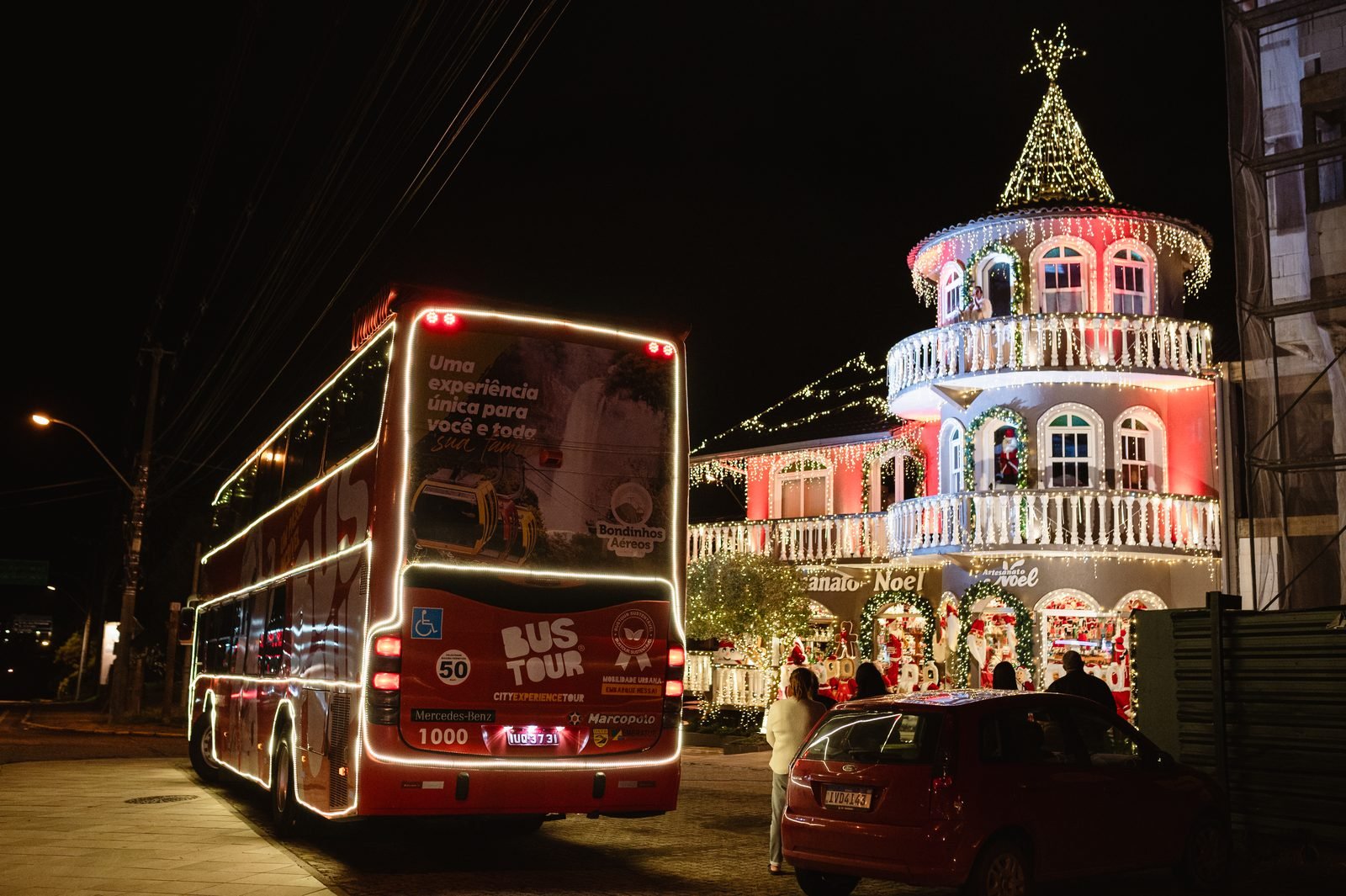 Artista vestido de Papai Noel se apresentando na calçada para os passageiros