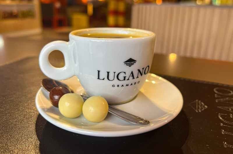 Xícara de café servida com bombons de chocolate sobre o pires