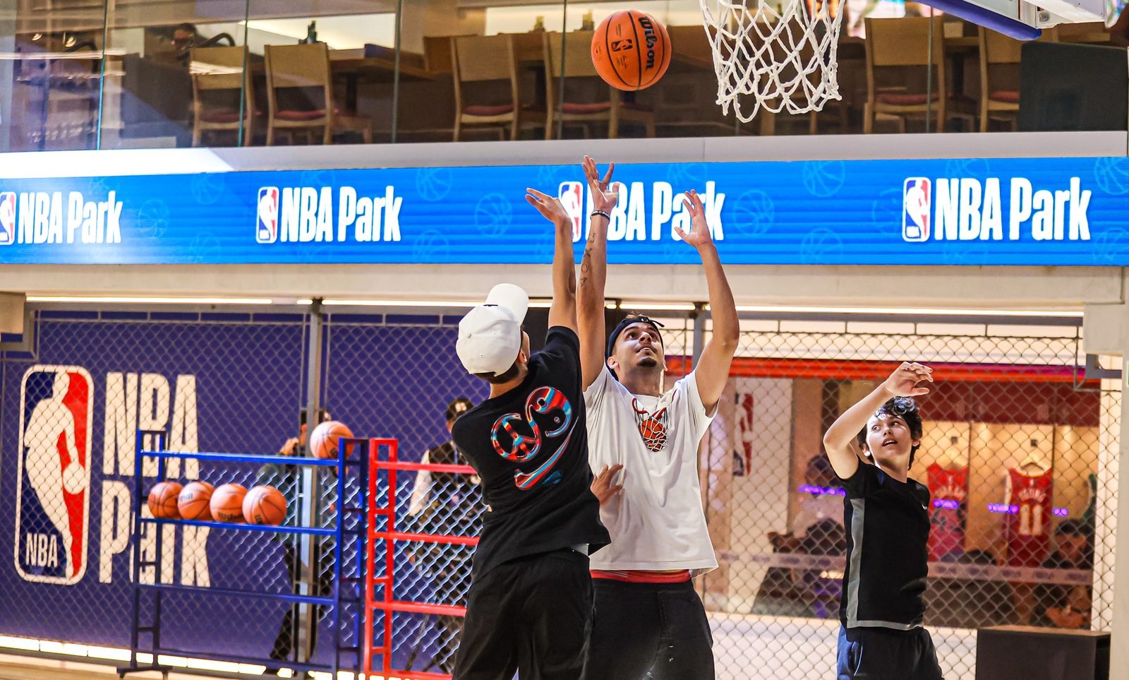 Visitantes arremessando à cesta na quadra do NBA Park