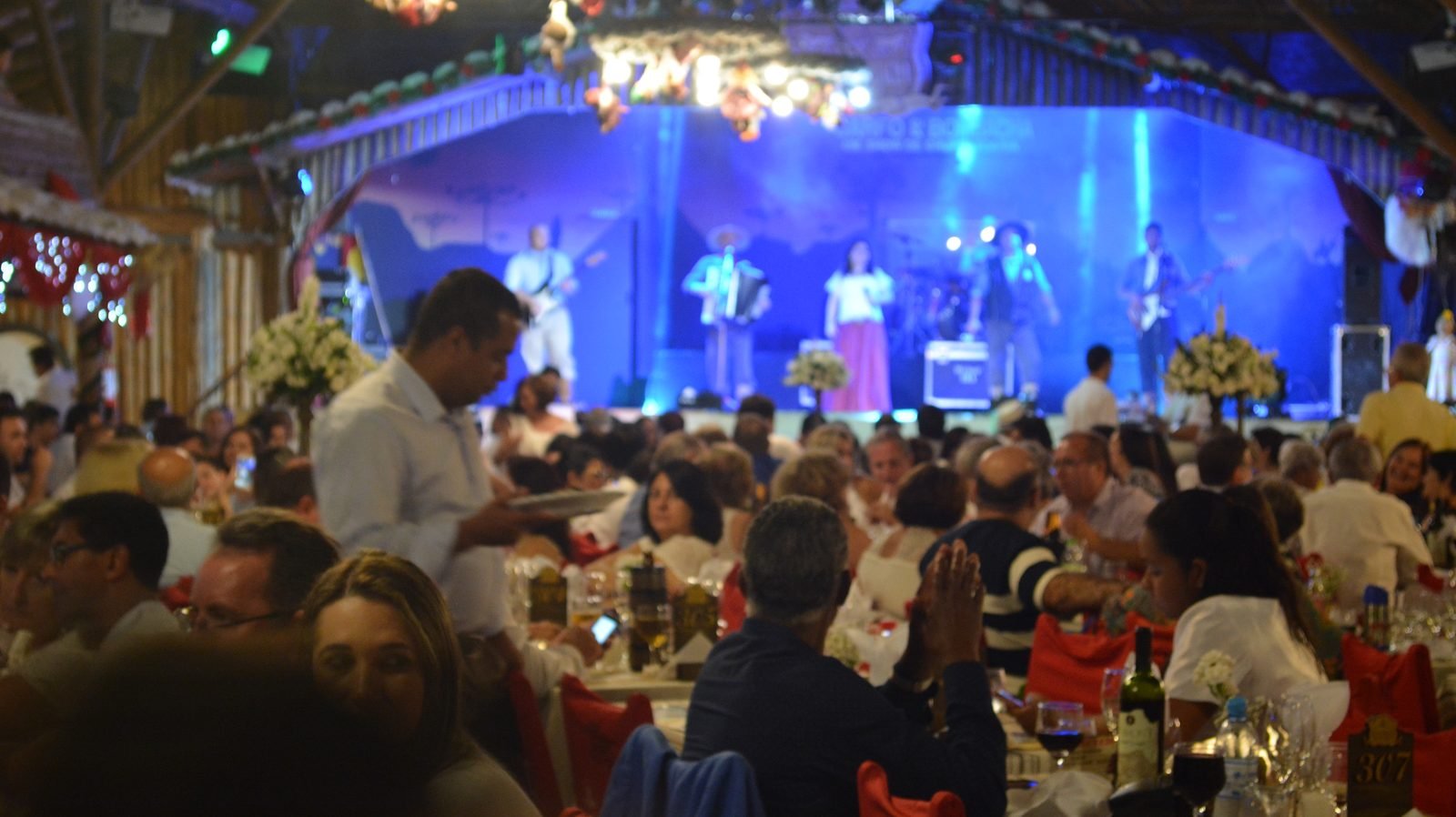 Mesa posta com churrasco servido durante a Noite Gaúcha