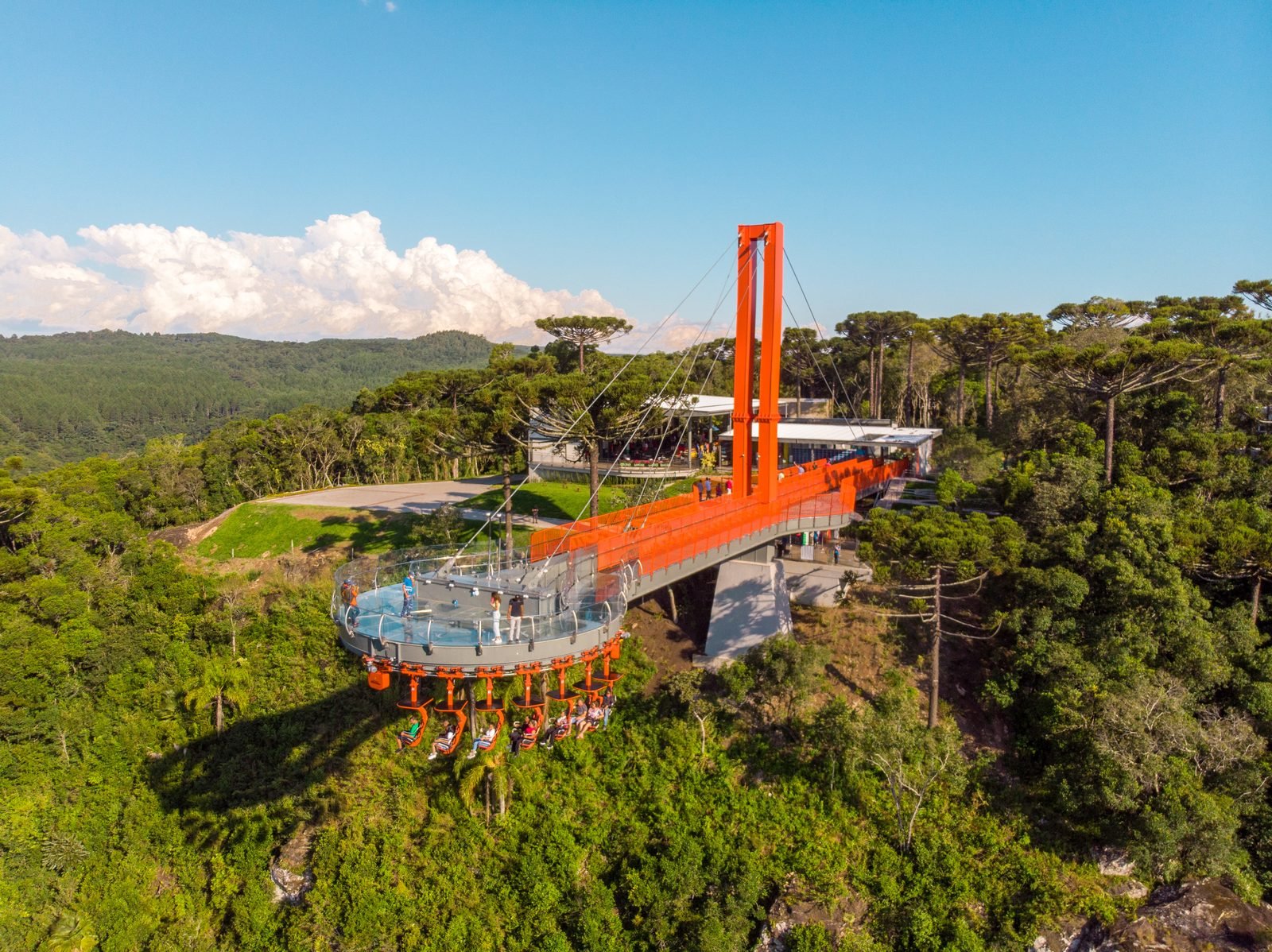 Vista aérea de toda a estrutura do Skyglass com visitantes na plataforma e os assentos do Abusado pendurados por baixo